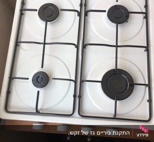כיריים גז לבנים עם ארבעה מבערים וכפתורי שליטה